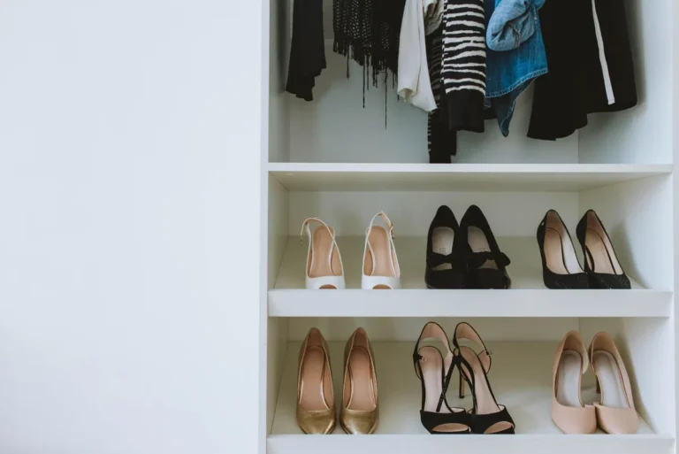 Organized narrow closet with the floor clear and shoes stored on the door