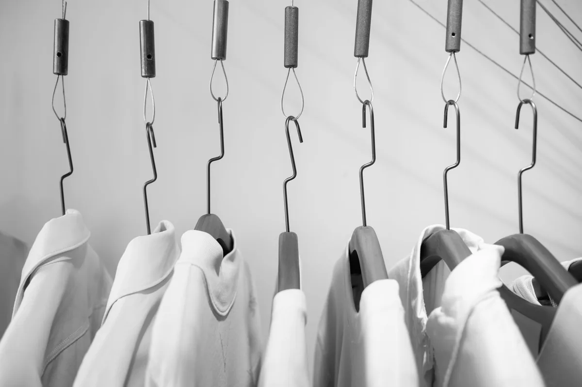 Clothes on a hanger rail showing how far hems overhang the closet floor